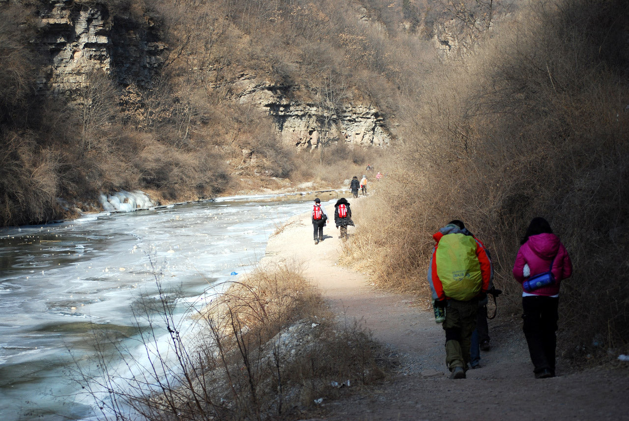 Hikers walking along a river