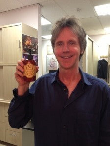 Dana Carvey holding a 8oz pump bottle of Skin Saver Barrier Lotion